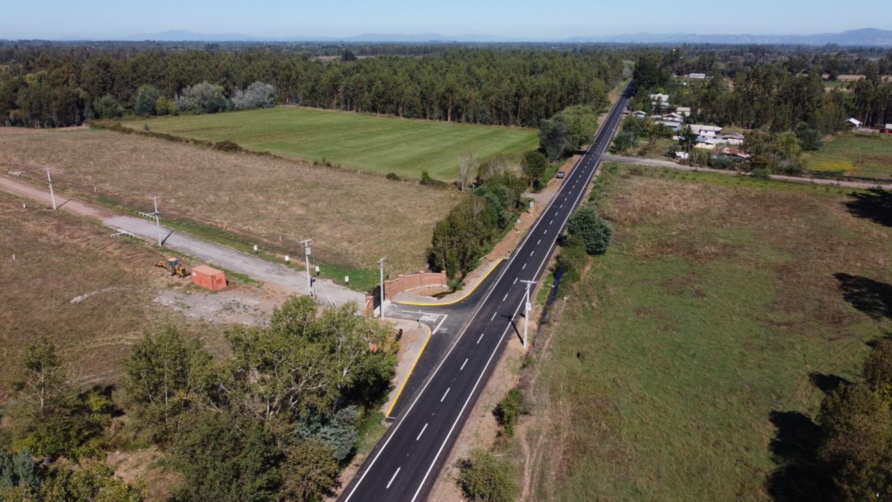Vista aérea del acceso y camino pavimentado hacia una parcelación